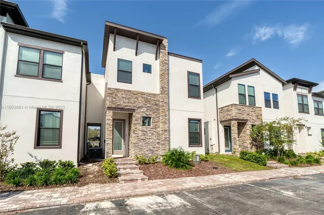 a front view of a house with yard and parking