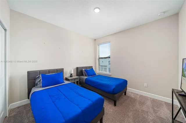 a bedroom with two beds and a chair