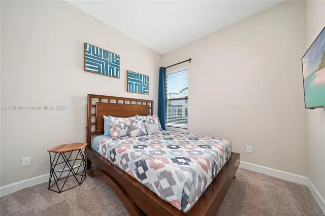 a bedroom with a bed and painting on the wall