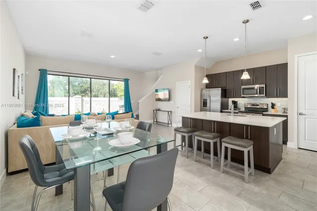 a large kitchen with kitchen island a sink table and chairs