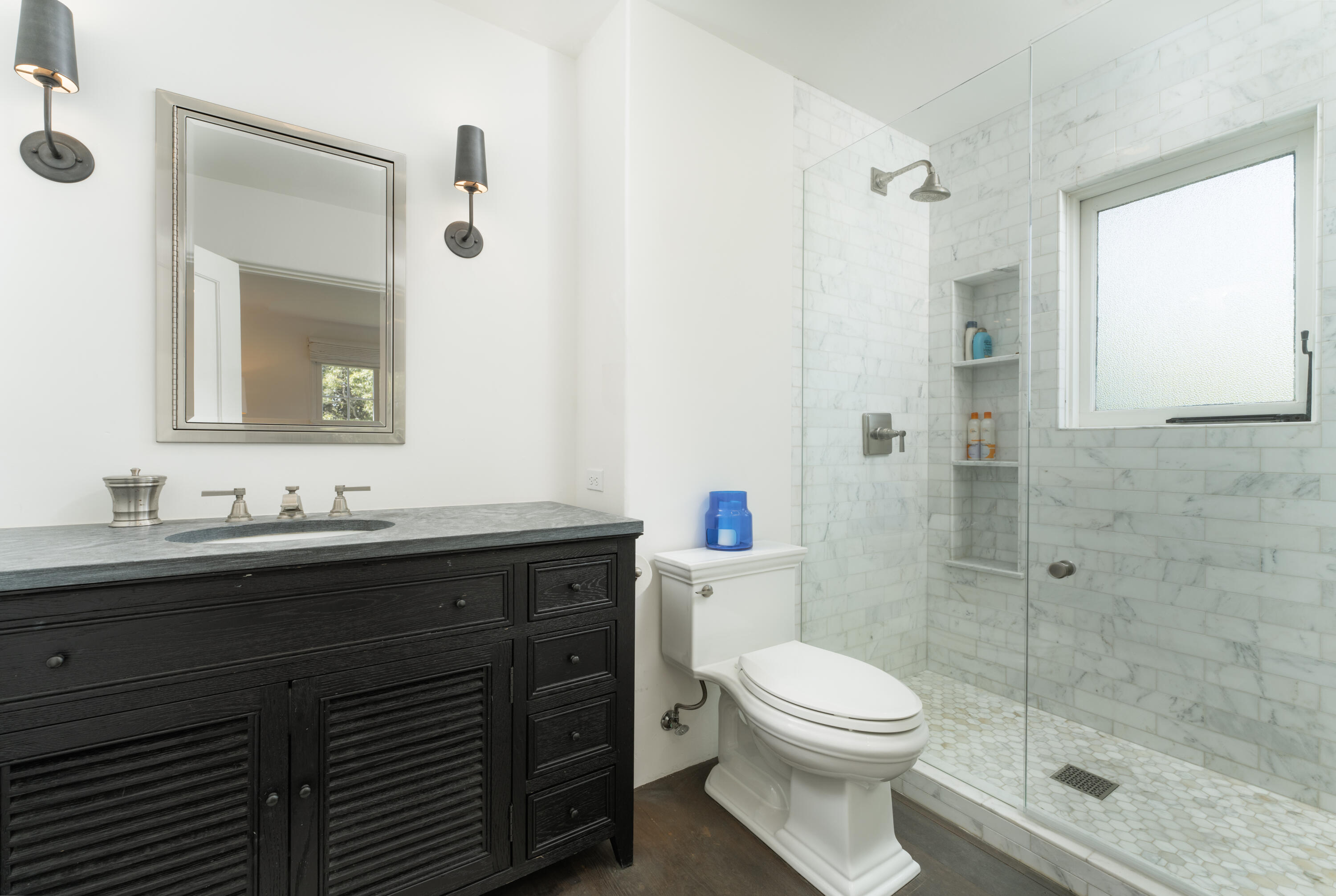 1365 Virginia Road Montecito, CA 93108 - Photo 17 of 38 a bathroom with a toilet a sink a glass door a shower and a mirror