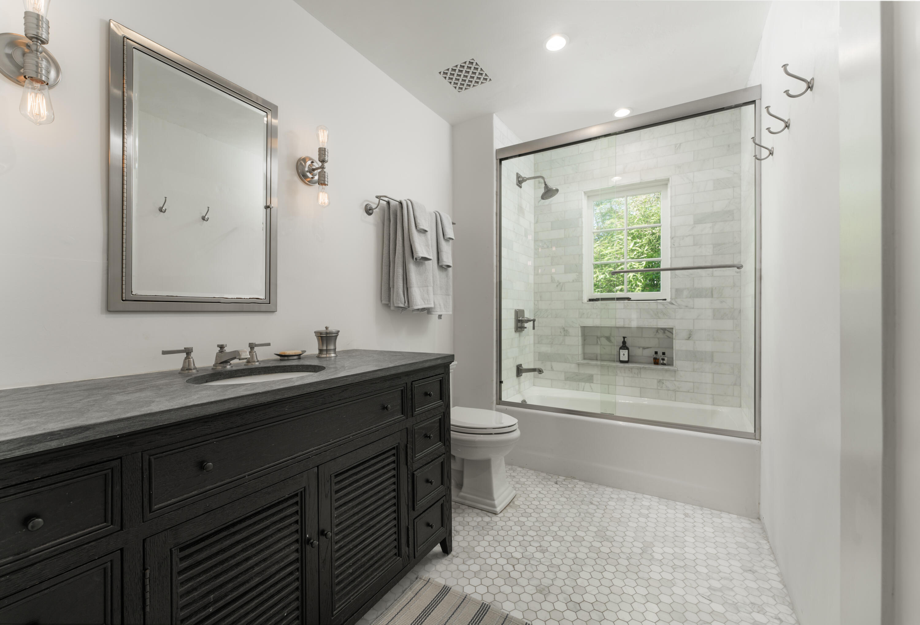 1365 Virginia Road Montecito, CA 93108 - Photo 20 of 38 a bathroom with a granite countertop sink toilet a large mirror a bathtub and shower