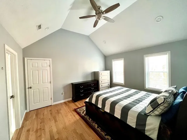 a bedroom with a bed and wooden floor