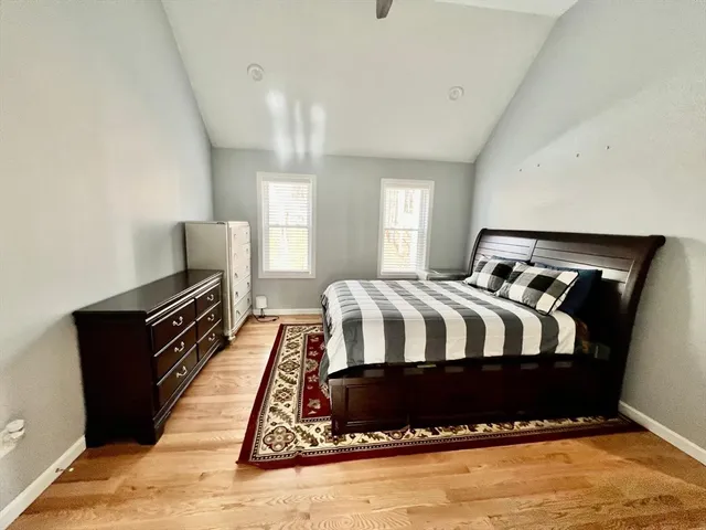 a bedroom with a bed and wooden floor