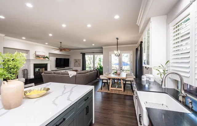 a living room with furniture a fireplace and a ceiling fan