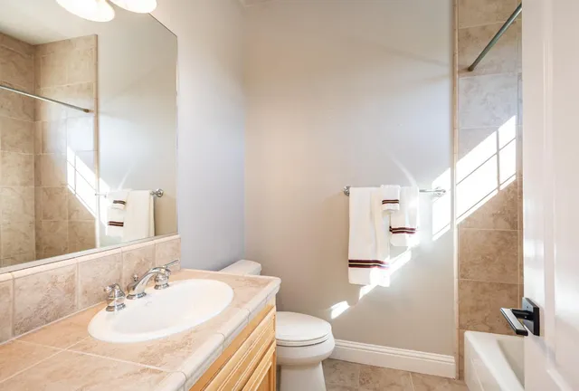 a view of a chair and table in backyard with potted plants
