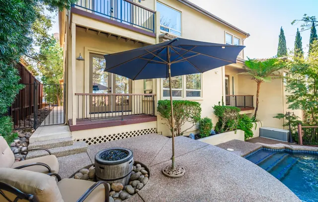 a view of a patio with table and chairs potted plants and large tree