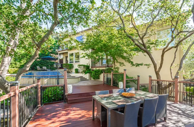 an aerial view of a house with swimming pool and large trees