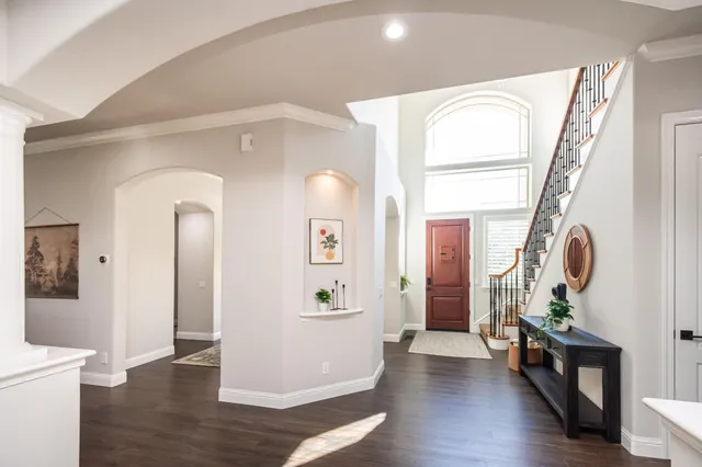 a dining room with wooden floor a chandelier a wooden table and chairs