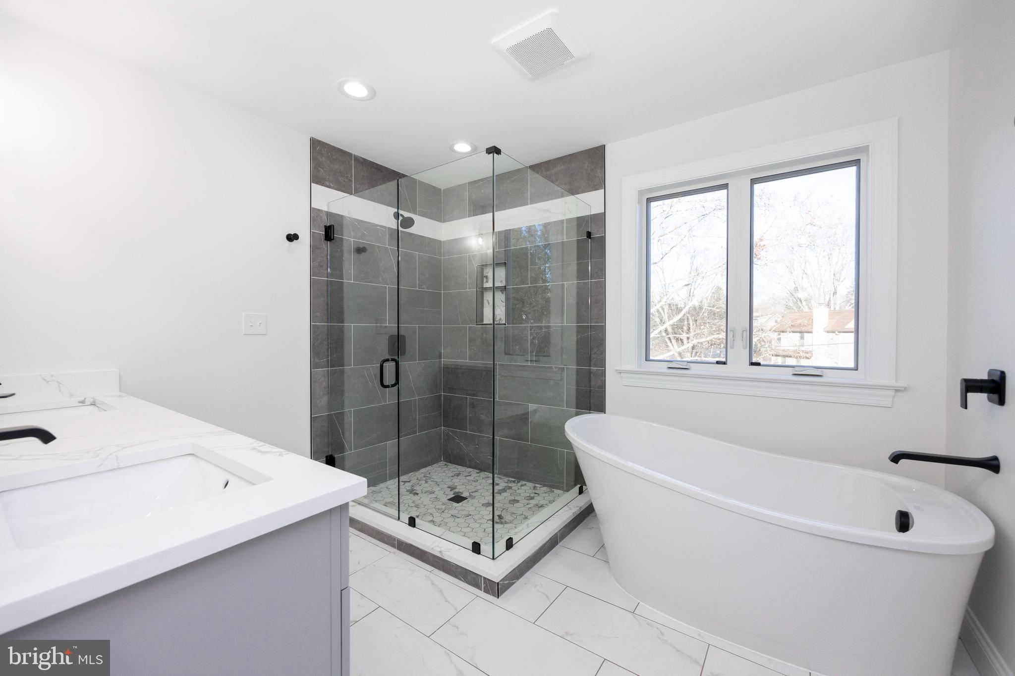 660 Little Conestoga Road Downingtown, PA 19335 - Photo 29 of 56 a bathroom with a tub a sink a window and a shower