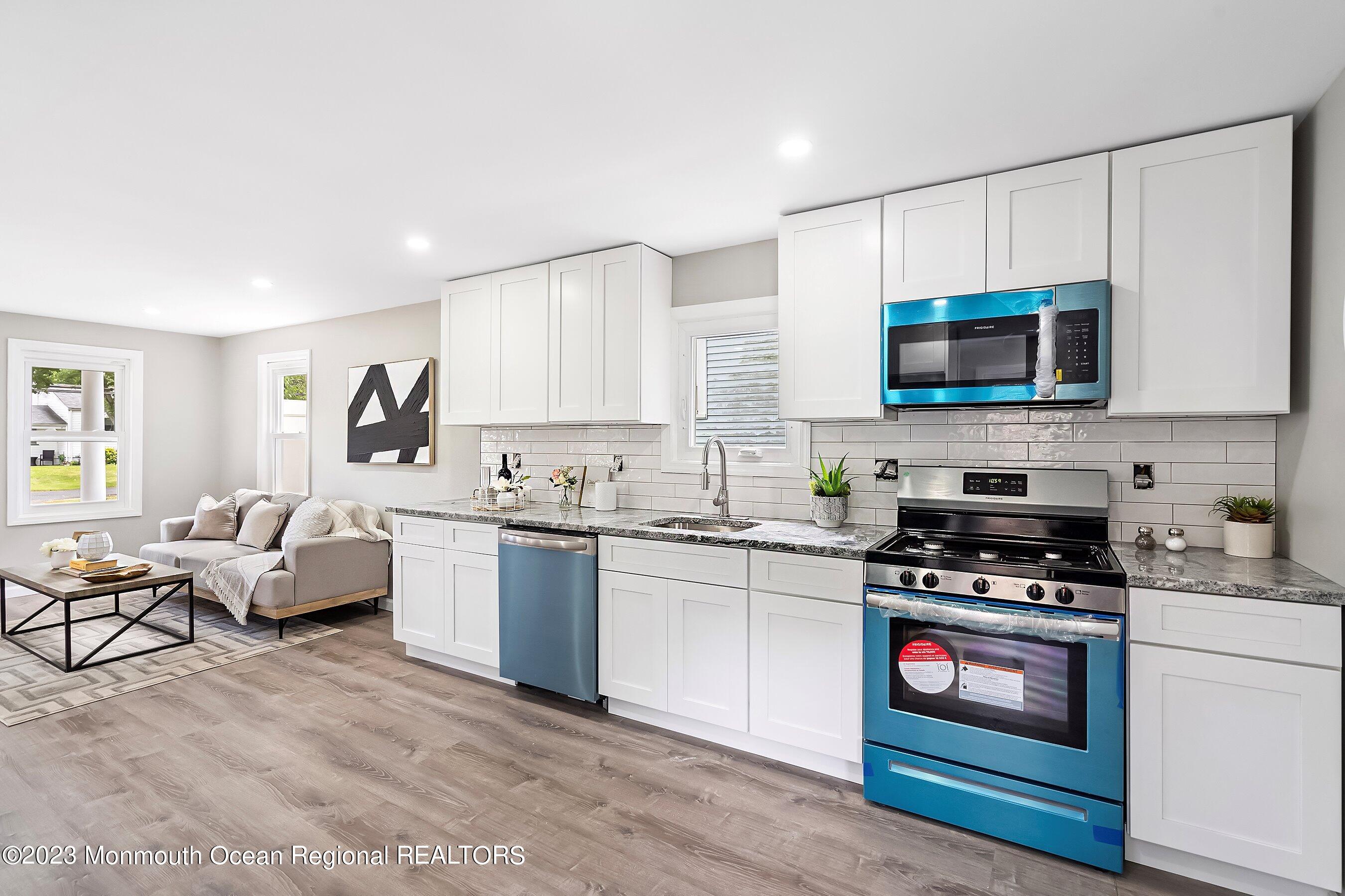 73 Main Street Englishtown, NJ 07726 - Photo 4 of 14 a kitchen with granite countertop a stove a sink and a microwave