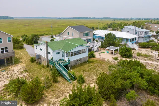 an aerial view of residential houses with outdoor space and ocean view
