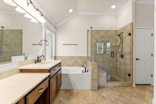 a bathroom with a tub sink shower and mirror
