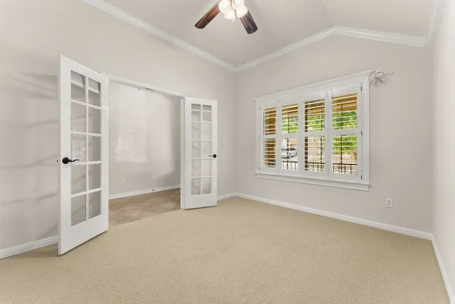 an empty room with windows and fan