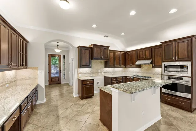 a kitchen with stove cabinets and refrigerator