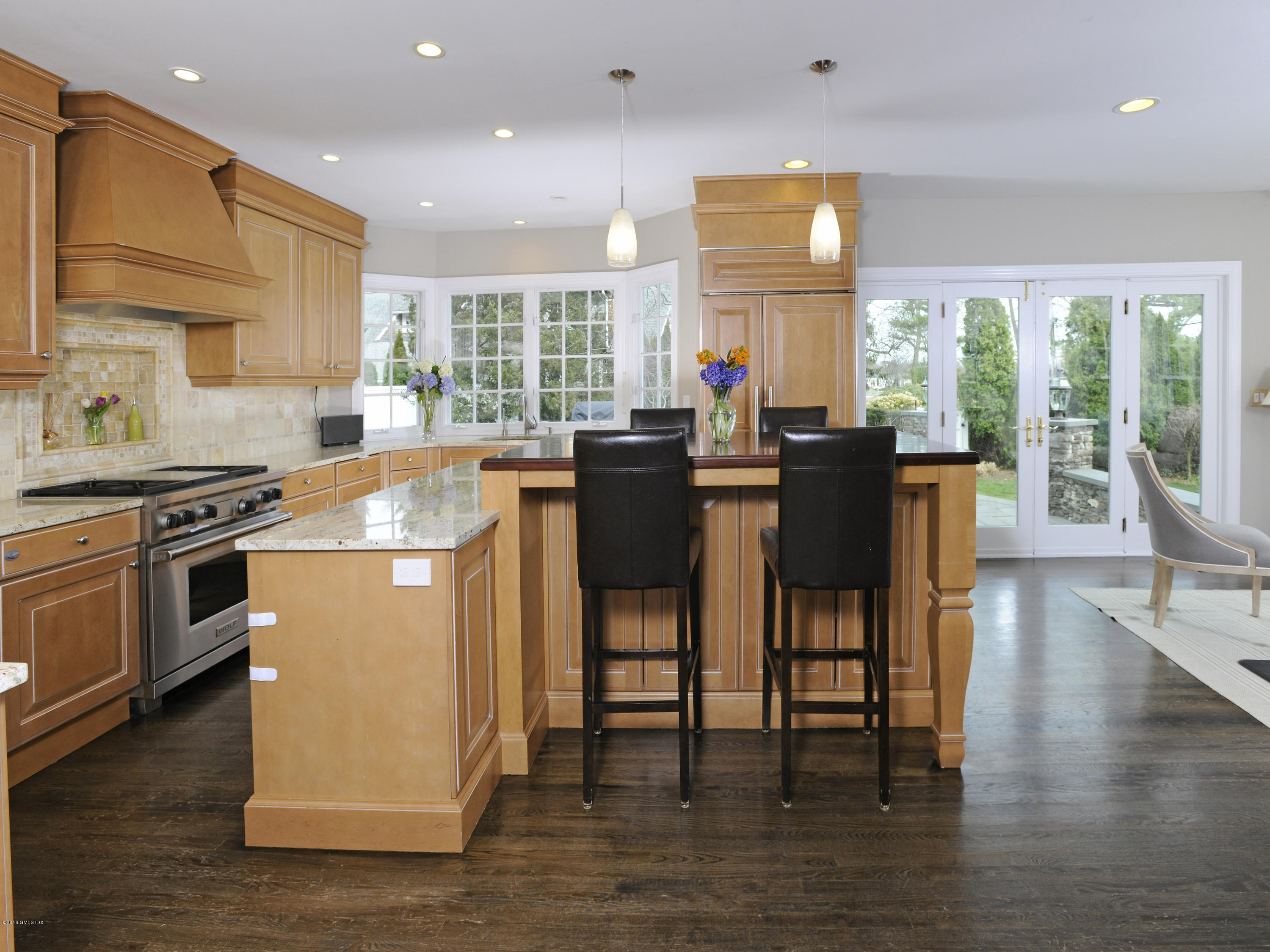 23 Willowmere Avenue Riverside, CT 06878 - Photo 2 of 21 a kitchen with stainless steel appliances granite countertop wooden floor sink stove dining table and chairs