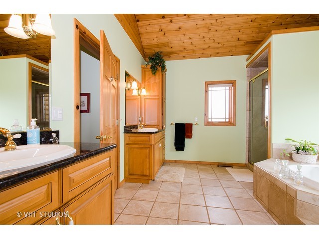 11411 Armory Road Hebron, IL 60034 - Photo 14 of 22 a bathroom with a tub sink and mirror