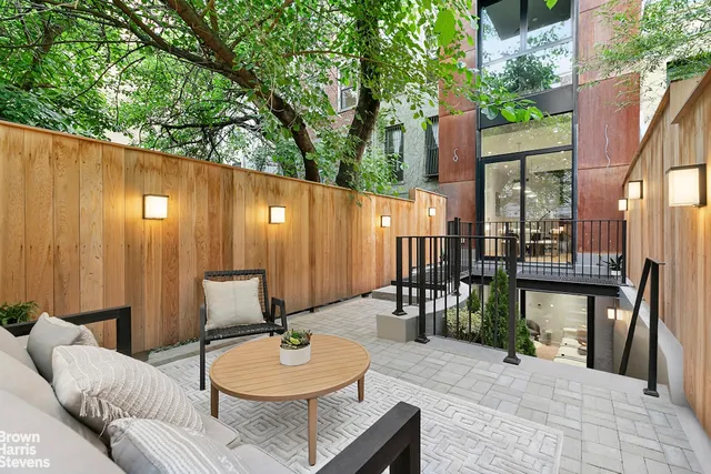 a backyard of a house with dining table and chairs