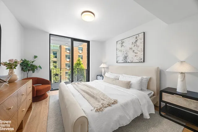 a bedroom with a large bed and a potted plant