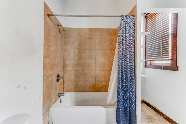 a bathroom with a shower curtain and a bathtub