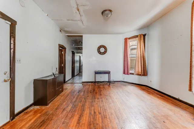 a view of an empty room with window wooden floor and a window