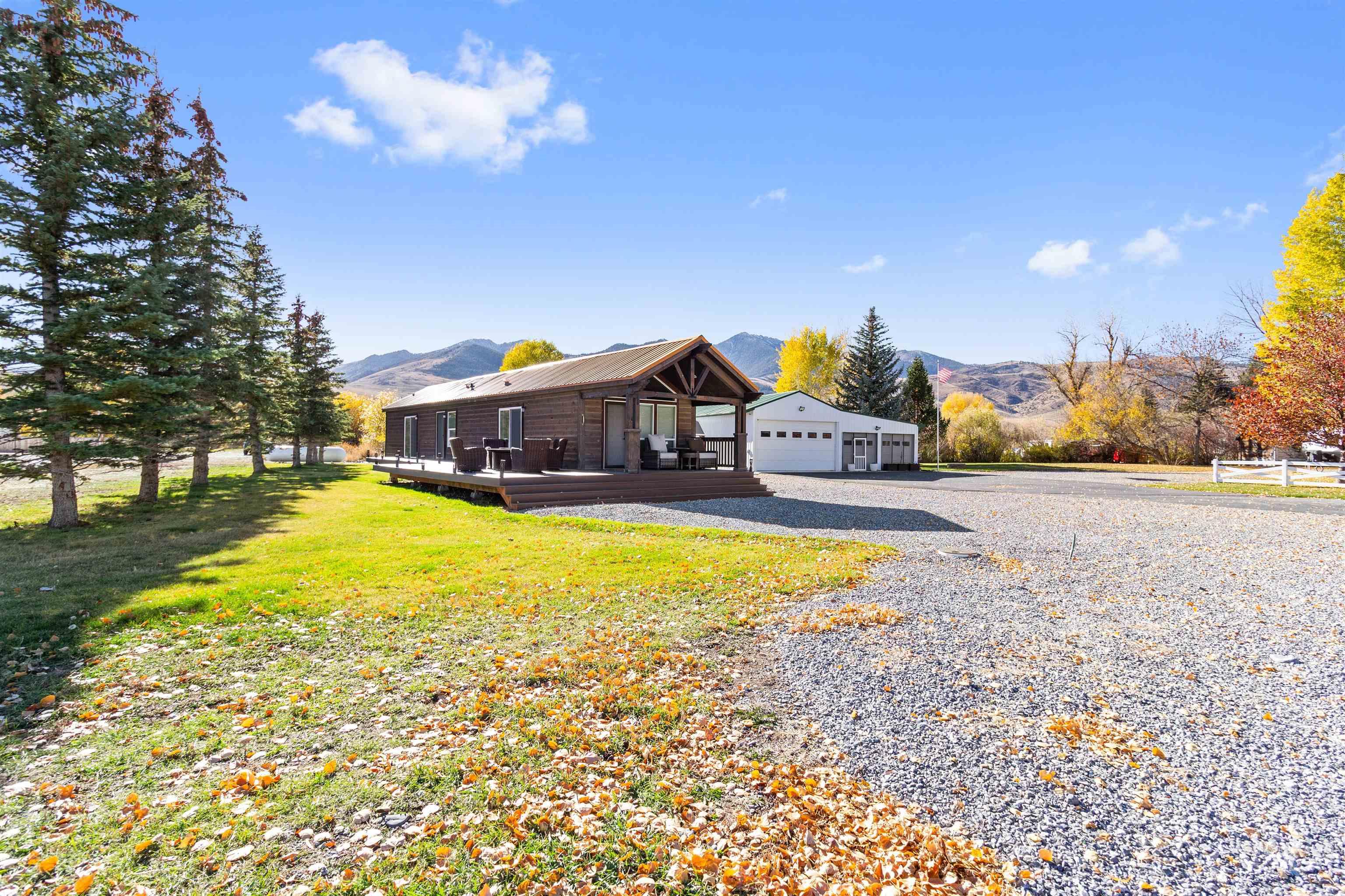 107 Willow Street Mackay, ID 83251 - Photo 4 of 48 View of front of home with a front lawn, a deck with mountain view, and a metal roof