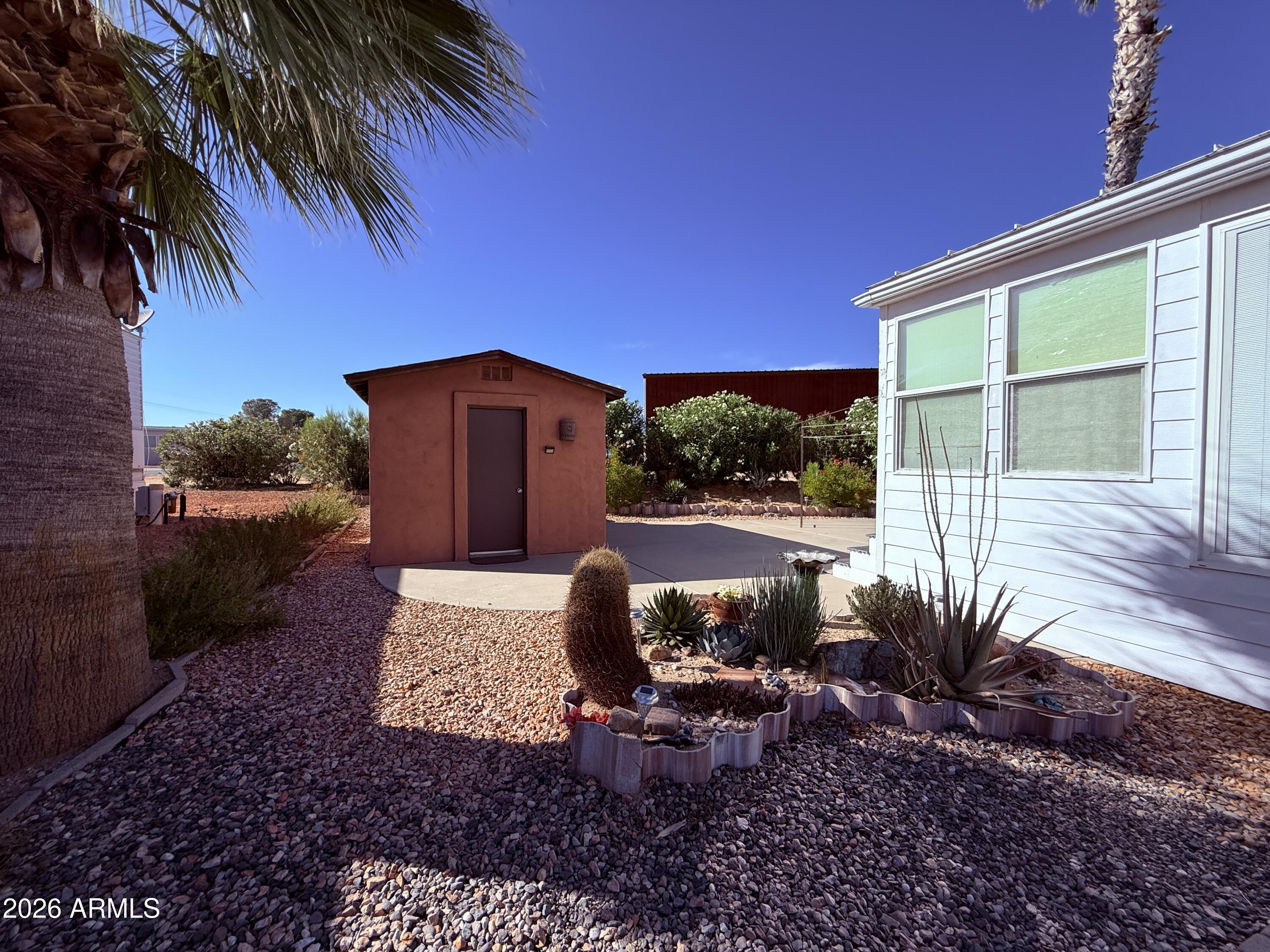 21340 Trading Post Trail Congress, AZ 85332 - Photo 2 of 31 a backyard of a house with table and chairs plants and large trees