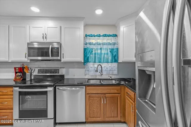 a kitchen with stainless steel appliances granite countertop a refrigerator and a stove top oven