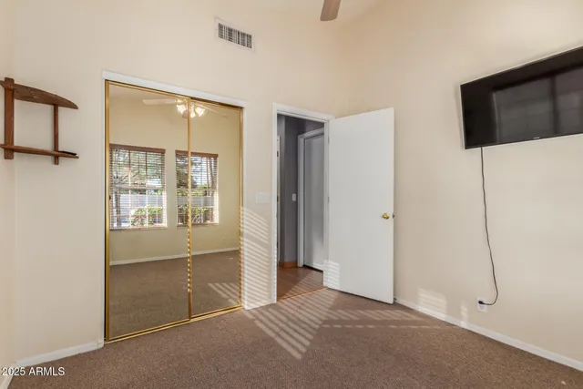 a view of an empty room with a window and a kitchen
