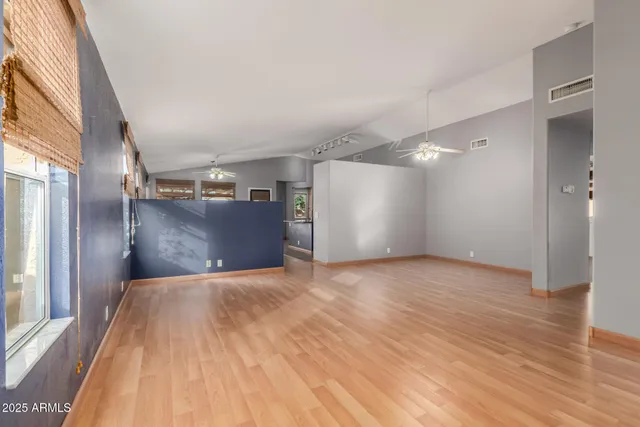 a view of a big room with wooden floor and a window
