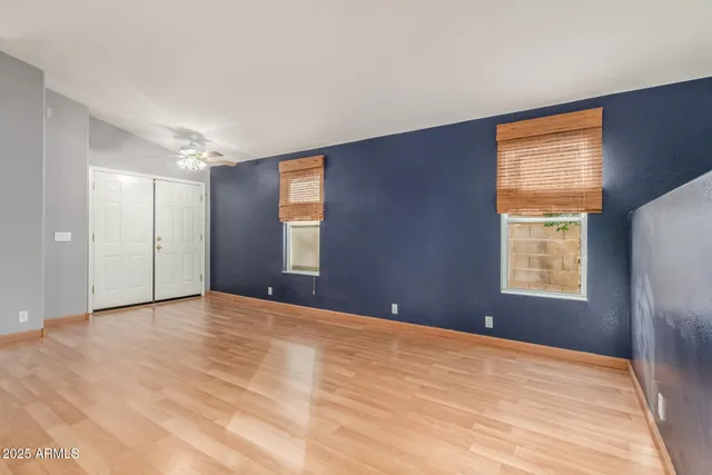 a view of an empty room with a window and a kitchen