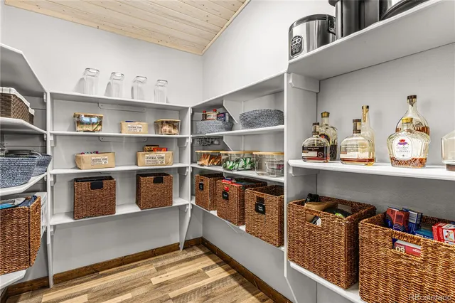 a kitchen with stainless steel appliances granite countertop a lot of cabinets and wooden floor