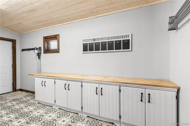 a view of a kitchen with white cabinets and wooden floor