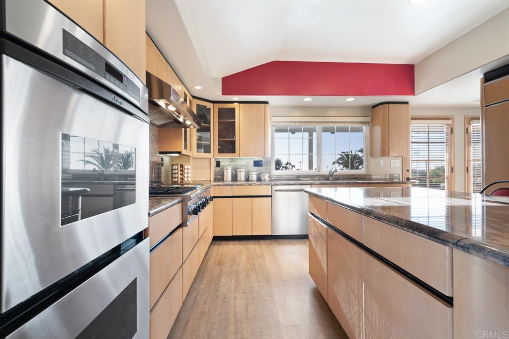 1754 Crest Drive Encinitas, CA 92024 - Photo 14 of 43 a large kitchen with stainless steel appliances kitchen island a large counter top and a wooden floors
