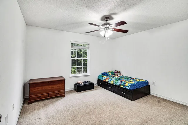a view of an empty room and chandelier fan
