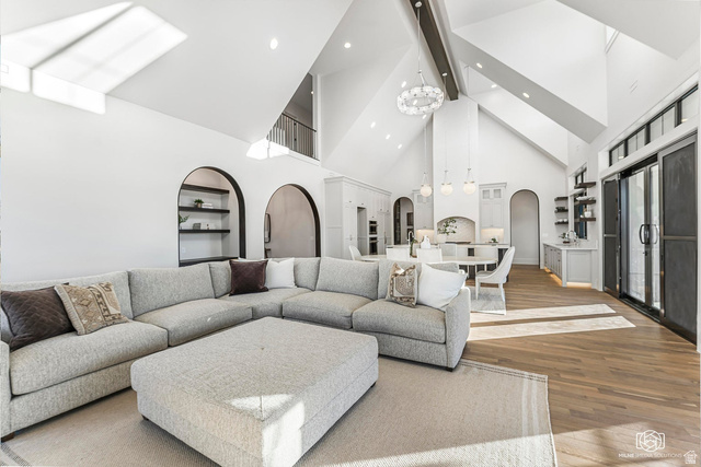 1468 South Red Cliffs Temple Lane St. George, UT 84790 - Photo 14 of 64 Living area with arched walkways, wood finished floors, built in shelves, a chandelier, and a skylight