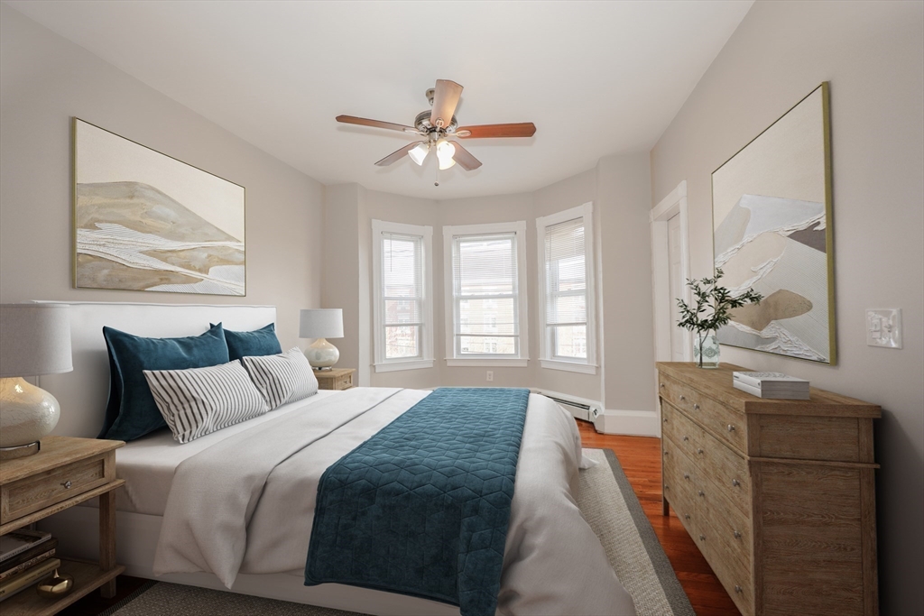 64 Bremen Street, Unit 3 Boston, MA 02128 - Photo 8 of 16 a spacious bedroom with a bed and a painting on the wall