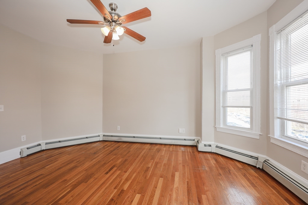 64 Bremen Street, Unit 3 Boston, MA 02128 - Photo 10 of 16 an empty room with wooden floor fan and windows