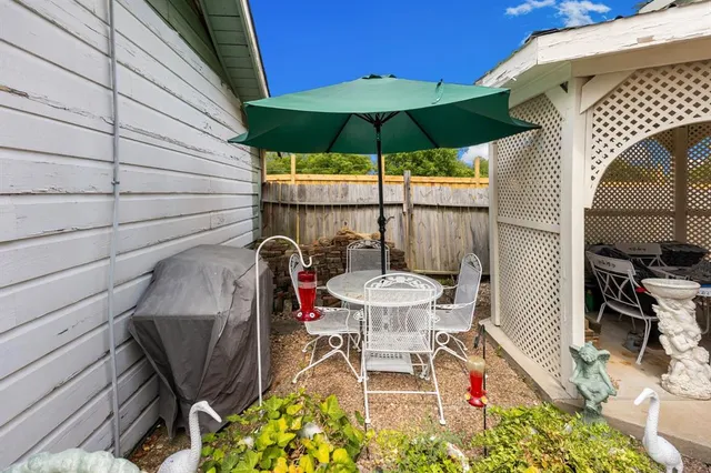 a view of a patio with table and chairs under an umbrella