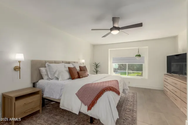 a bedroom with a large bed and a flat tv screen on dresser