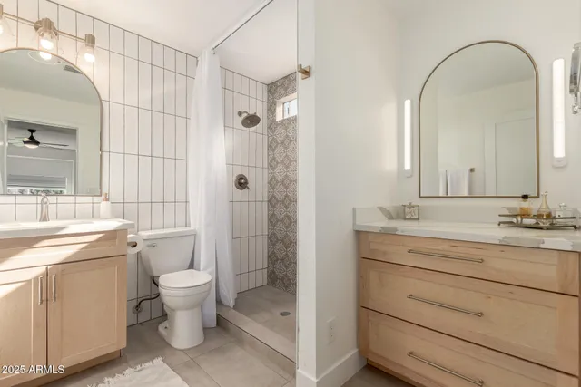 a bathroom with a double vanity sink toilet and shower