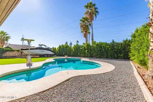 a view of a swimming pool with a yard and plants