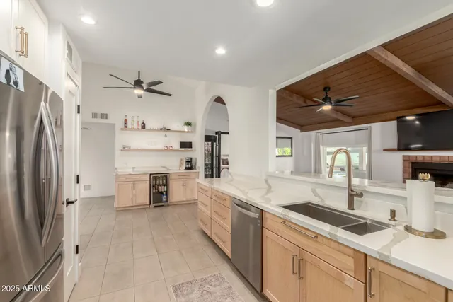 a large kitchen with stainless steel appliances a sink a refrigerator and a counter space