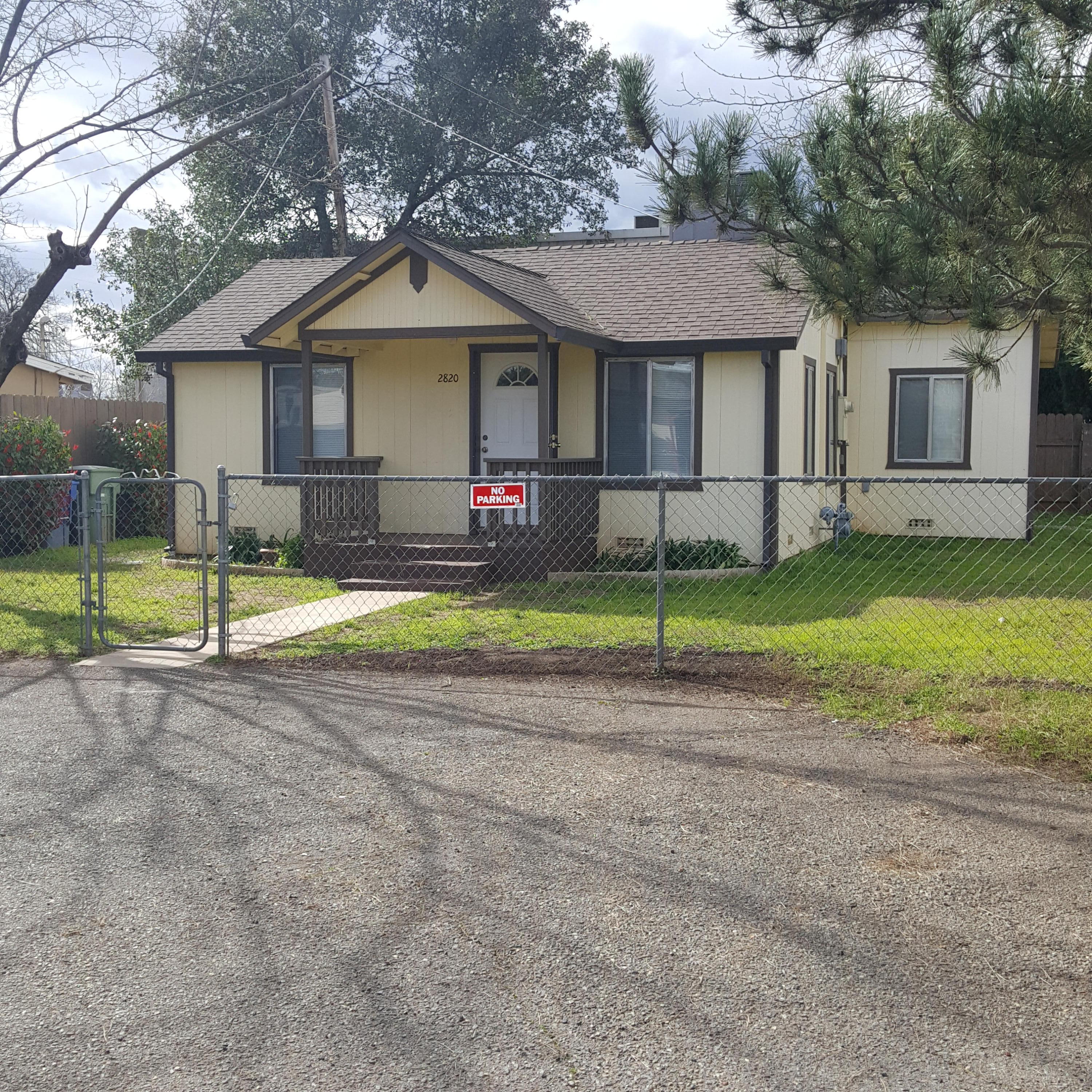 a view of a house with a yard and large tree