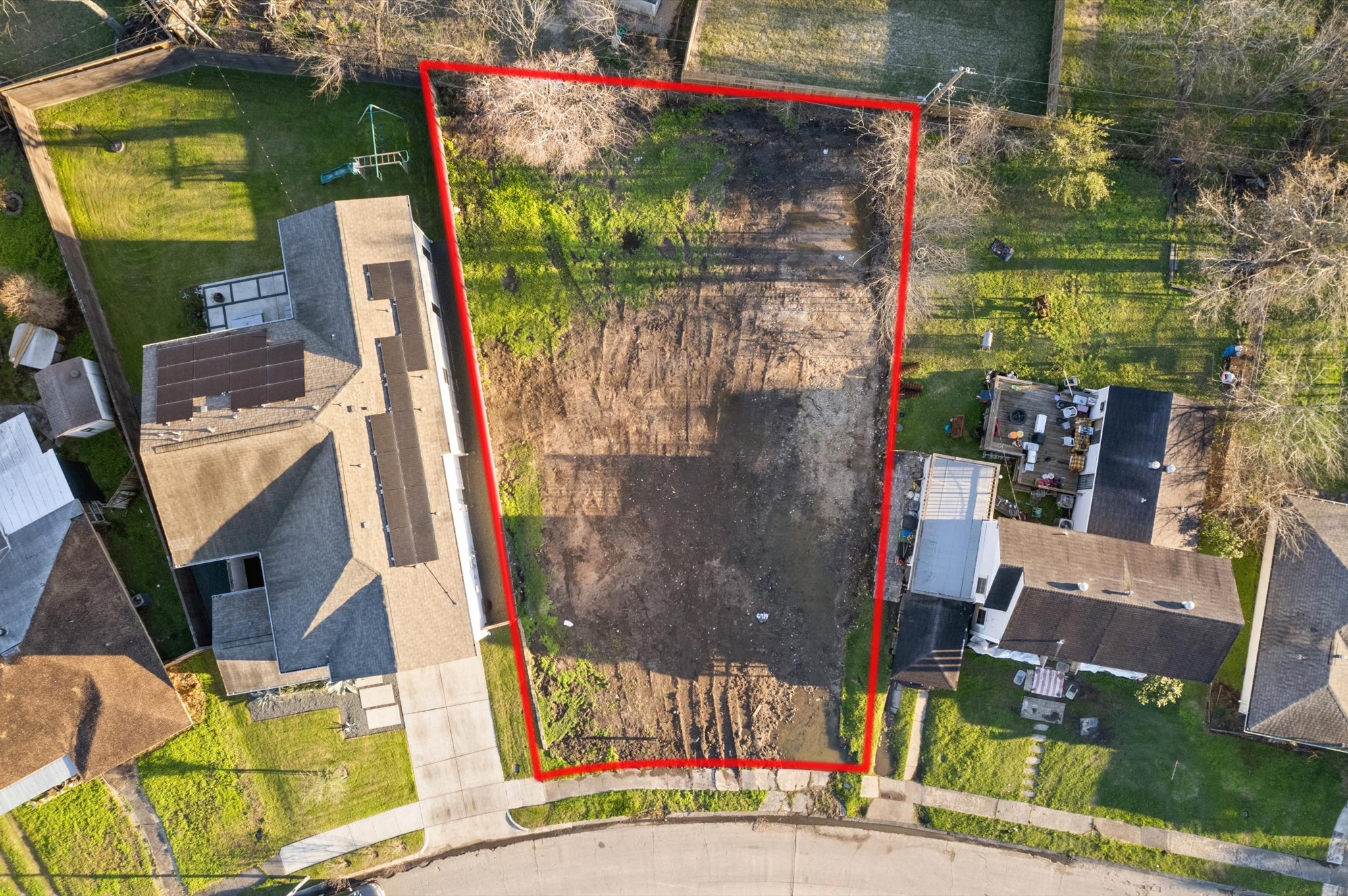 6919 Burgess Street Houston, TX 77021 - Photo 12 of 12 This photo shows a vacant lot outlined in red, situated between two residential properties. The lot is cleared and ready for development, offering spacious potential for building in a neighborhood setting.