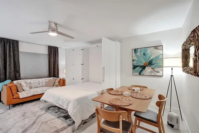 a spacious bedroom with a bed a lamp and a flat screen tv