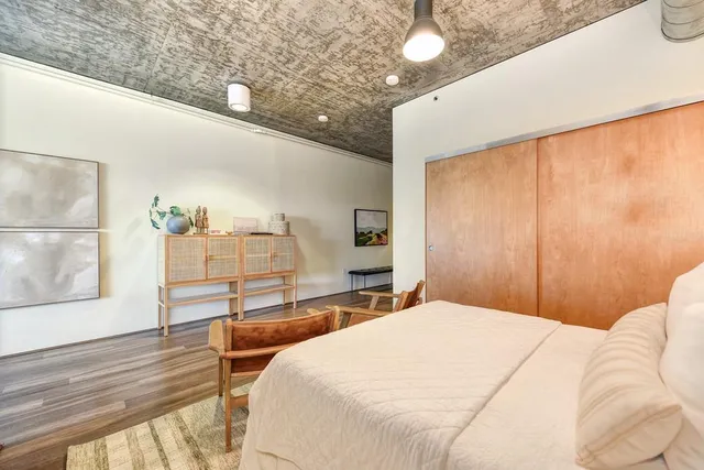 a bedroom with a large bed and wooden floor