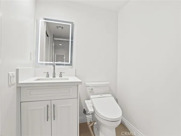 a bathroom with a sink toilet and a mirror