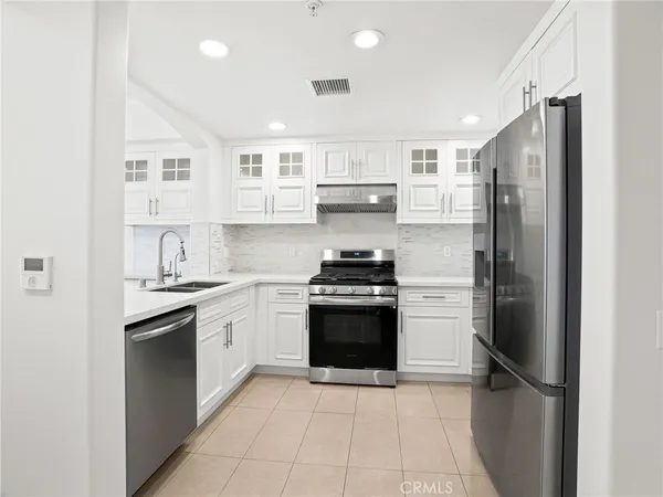 a kitchen with stainless steel appliances granite countertop a refrigerator sink and stove