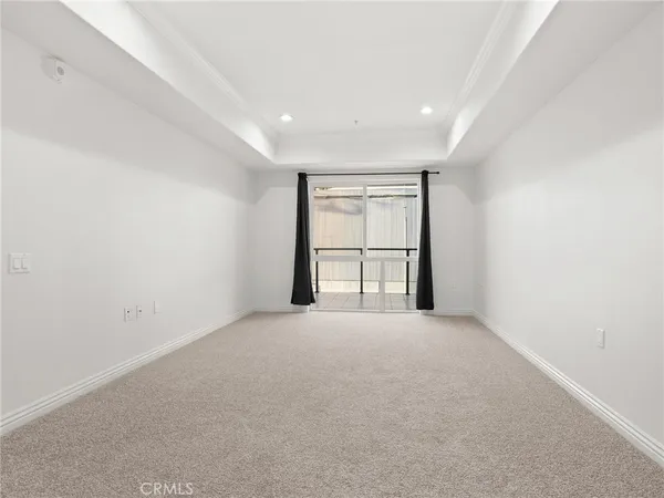 an empty room with windows and ceiling fan